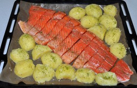 Рядом раскладываем картофель, смешанный с маринадом и рубленой зеленью. В духовку ставим, когда нагрелся гриль. Под ним при температуре 250° запекаем рыбу с картошкой 15-20 минут.