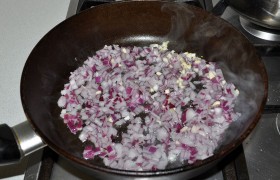 Примерно через полтора часа начинаем готовить глазурь. Пока разогревается на среднем огне масло в сковороде, измельчаем лук и чеснок. Помешивая,  пассеруем  9-10 минут, пока лук становится мягче.