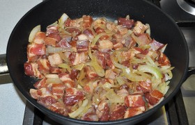 Выкладываем свинину, кусочки которой уже вобрали в себя весь соевый соус. На том же сильном огне 4-5 минут обжариваем мясо, не переставляя помешивать.