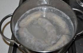 Заливаем колбаски небольшим количеством холодной воды. Дождавшись закипания, огонь снижаем и на малом – отвариваем пару минут. Заливать кипяток не стоит – оболочка может лопнуть.