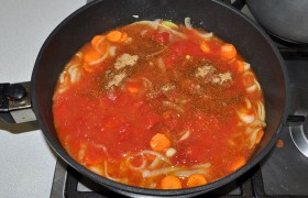Добавляем томатную пасту, вино, приправу к мясу, лавровый лист, соус тихо кипит 2-3 минуты. Выкладываем помидоры из банки вместе с соком, слегка раздавливаем лопаткой. 