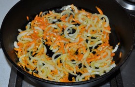 Тонкие полукольца лука и тертую крупно морковку засыпаем в сковороду, где уже разогрето на среднем огне масло. Нечасто помешивая,  пассеруем  овощи 9-10 минут. 