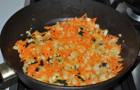 Шинкуем средним кубиком лук, трем морковь. На среднем огне разогреваем масло, овощи  пассеруем  6-7 минут. 