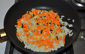 Добавляем крупно тертую морковку, продолжаем обжаривать и помешивать еще 3-4 минуты.