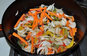 А в сковороде на этом же самом сильном огне быстро жарим при помешивании морковь с луком и сладким перцем – 2,5-3 минутки.