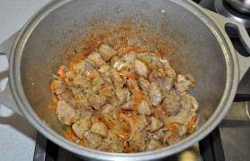 Кладем морковь, на обжаривание которой тратим 3-4 минуты. Посыпаем солью, перцем, паприкой, карри, приправой для мяса, уцхо сунели, помешиваем мясо с овощами полторы-две минуты.