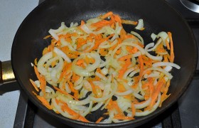 Вторую луковицу нарезаем полукольцами, натираем морковку. В сковороде, разогретой с маслом на среднем огне конфорки,  пассеруем  овощи 7-8 минут. 