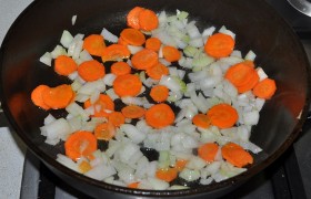 Разогреваем еще немного масла, на средне-сильном огне 3-4 минуты обжариваем, помешивая, мелкие кубики лука и кружки моркови (или крупно натертую).