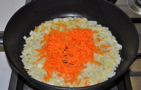 Тонко натираем и добавляем в сковороду морковь, продолжаем обжаривать 3 минуты.