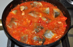 Кладем полоски сладкого перца. После закипания закладываем куски рыбы в соус, поливаем соусом сверху. Блюдо закипело - накрываем крышкой, на малом огне тушим примерно 20 минут, до готовности рыбы.