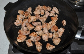Мясо (половину или всё) закладываем в сковороду, в которой уже  раскалилось  масло, на сильном огне обжариваем при помешивании мясо до корочек, 2-4 минуты.
