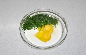 В миску с йогуртом разбиваем яйца, солим, кладем зелень, венчиком взбиваем – это заливка для пирога.