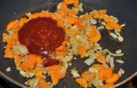 В сковороду добавляем томатную пасту, размешиваем, кладем сахар, тушим 3-4 минуты. 