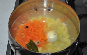 Добавляем также тертую морковь, лавровый лист. Варим 5-6 минут до почти готовности картошки.