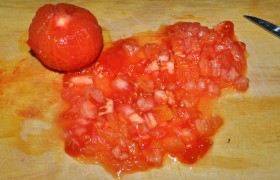 Этих минут нам хватит, чтобы залить на минутку кипятком надрезанные помидоры. Сливаем кипяток, опускаем в воду холодную. Кожица легко снимается, а мякоть мы мелко рубим.