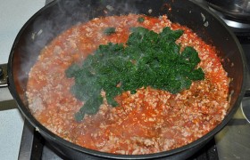 Добавляем шпинат, приправляем перцем и солью, травами. На небольшом огне обжариваем фарш с добавками (а точнее, мясной соус), который за 5-6  минут выпаривается до нужной густоты. В конце вмешиваем в соус измельченный чеснок.