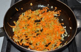 Для  суповой заправки  разогреваем масло на среднем огне, засыпаем мелко нашинкованный лук, периодически помешивая,  пассеруем  5-6 минут. Кладем тертую морковь и обжариваем овощи еще 4-5 минут.