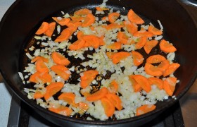 Ставим на конфорку кастрюлю с 1,5-1,8 л воды. На конфорке другой разогревается сковорода с растительным маслом на среднем огне. В нее мы закладываем лук, шинкованный мелким кубиком, как и положено для заправки, и тертую либо тонко нарезанную морковь.  Пассеруем  6-7 минут, помешивая иногда. 