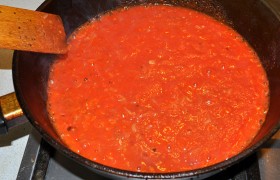 Вливаем томатную массу в сковороду, немного солим, посыпаем сахаром, тушим открытой около 15 минут, до выпаривания жидкости и загущения соуса.