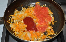 Добавляем томатную пасту, тертый помидор, перемешиваем. Вливаем немного бульона, оставляем тушиться 4-5 минут.