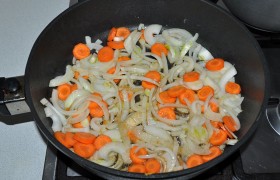 В освобожденную сковороду всыпаем нашинкованные лук с морковью, ставим средний огонь,  пассеруем  овощи 8-9 минут. Приправляем немного перцем и солью. 