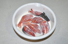 Раскладываем стейки в миске и заливаем на 20-25 минут молоком. Этот простой прием удаляет характерный запах рыбы, делает ее сочнее и вкуснее.