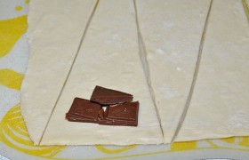 Шоколад либо натираем, либо ломаем на небольшие кусочки. На основании каждого треугольника выкладываем рядок из нескольких кусочков шоколада.