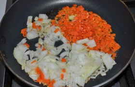 Сковороду с маслом разогреваем на среднем огне, загружаем в нее нашинкованные лук и морковь.  Пассеруем  8-9 минут. И в это же время ставим на огонь кастрюлю с мясным бульоном или водой, 2-2,5 л.