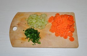 Подготавливаем овощи: тонко нарезаем морковь и сельдерей, что удобно делать на стороне терки, назначенной для шинковки капусты. Мелко рубим зеленый лук.