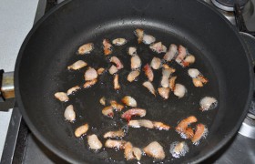Свиное сало превращаем в небольшие ломтики и обжариваем на сковороде или в толстостенной кастрюле до вытапливания жира. Сильный огонь не нужен – средний. Вынимаем шкварки. Кстати, в это блюдо пойдет и соленое сало, и даже слой сала с копченой свинины.