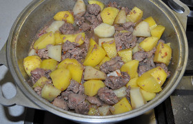 В латку добавляем нарезанный картофель, воды или бульона и тушим на небольшом огне до готовности картофеля (примерно 12-15 минут).