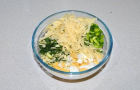Для начинки соединяем порубленные кубиком яйца, тертый сыр,  нарезанную зелень и лук. 