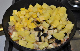 Теперь закладываем картофель - перемешиваем. Далее – баклажан, кабачок. Все это - постоянно помешивая и переворачивая овощи с мясом.