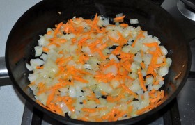 Добавляем морковь, нарезанную или пропущенную через терку. Обжариваем 3-4 минуты.