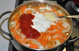 Заливаем кипятком и добавляем остальные составляющие соуса - кетчуп, сметану, лук, морковь. Солим.