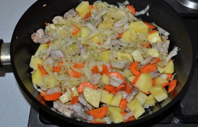 Добавляем картофель, морковь и, все также перемешивая, обжариваем еще 2-3 минуты. То есть на жарку уходит 9-10 минут.