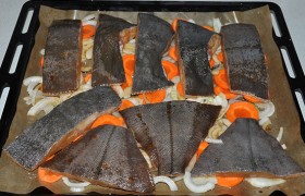 Обсушенную рыбу раскладываем на овощах, ставим противень или форму на средний уровень. Запекаем 20-25 минут при температуре 220°.