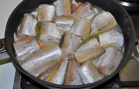 Укладываем куски рыбы, вливаем 2-2,5 стакана кипятка, добавляем соли, перца. На сильном огне доводим до закипания, накрываем. На маленьком огне оставляем на 10-12  минут. Рыба уже готова, вынимаем ее на тарелку.