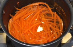 Яйцо для заправки салата ставим варить. Морковь пропускаем через терку для корейской моркови (или обычную), заливаем немного кипятка, солим, бросаем гвоздички – и пусть тушится на слабом огне 3-4 минуты, не до полной мягкости.