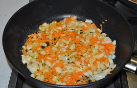 Во вторую сковороду наливаем 2-4 ст. ложки масла, ставим на сильный огонь. Нарезаем лук, натираем морковь, кладем в масло и обжариваем 3-4 минуты при помешивании.