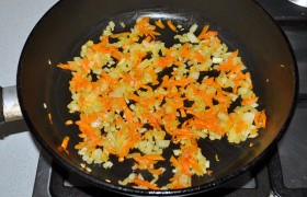 Для заправки шинкуем лук, натираем морковь. В разогретое на сковороде растительное масло (средний огонь) кладем овощи, помешивая периодически,  пассеруем  9-10 минут. Вливаем немного бульона и тушим 3-4 минуты.