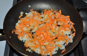Готовим овощную  заправку  для супа. Мелко порубленную луковицу и тертую морковь  пассеруем  в сковороде на среднем огне 6-8 минут, до прозрачности лука. 
