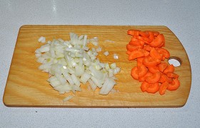 Подготавливаем овощи для заправки. Шинкуем кубиком луковицу и нарезаем (либо пропускаем через терку) морковь.