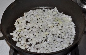 Пока на среднем огне разогревается в большой сковороде масло, нарезаем лук и морковь. Сначала, периодически помешивая,  пассеруем  5-7 минут лук.