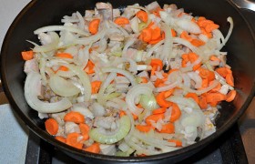 На второй сковороде, с толстым дном, ставим  перекаливаться  на сильном огне растительное масло, выкладываем нарезанное небольшим кубиком мясо, обжариваем 2-3 минуты, пока свинина посветлеет. Добавляем нашинкованные луковицу и морковь, помешиваем, 