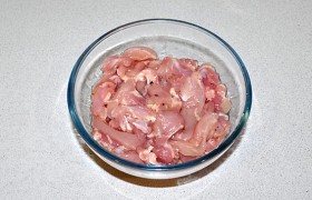 В миску с мясом вливаем 1-1,5 ст. ложки растительного масла, посыпаем перцем и перемешиваем.