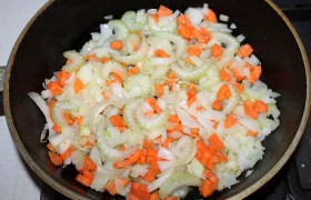 Пару ложек растительного масла ставим в сковороде на средний огонь разогреваться, шинкуем очищенные лук, морковь, промытый и обсушенный сельдерей, все это загружаем в сковороду. Помешивая порой, томим на конфорке 6-8 минут.