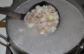 Готовое мясо вынимаем из кастрюли. Процеживаем бульон. Снимаем мясо с кости,  нарезаем говядину кусочками, снова кладем в бульон. Туда же выкладываем и сваренную перловку, и нарезанный небольшими кубиками картофель. Закипевший суп накрываем крышкой и на небольшом огне пусть варится минут 10-15. 