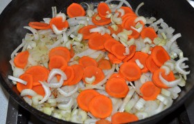 А в освободившуюся сковороду кладем нашинкованный лук и сельдерей, морковь, которые томятся 10 минут на среднем огне, впитывая оставшиеся от жарки соки. 