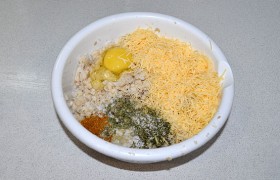 В миске соединяем рыбу, мелко тертый сыр, яйцо, зелень, замоченные в молоке кусочки белого батона.